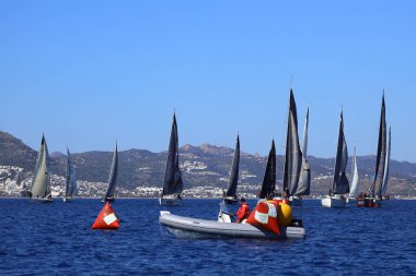 Bodrum, Hindi. 24 Şubat 2024: Ege Denizi 'nin mavi sularında, ünlü tatil beldesi Bodrum' un kıyılarında yelkenliler rüzgarlı havada yelken açıyor.