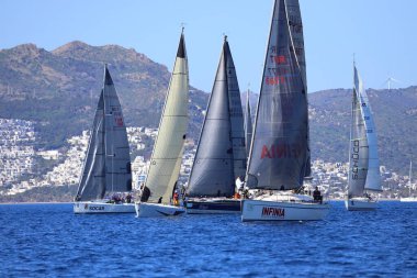 Bodrum, Hindi. 24 Şubat 2024: Ege Denizi 'nin mavi sularında, ünlü tatil beldesi Bodrum' un kıyılarında yelkenliler rüzgarlı havada yelken açıyor.