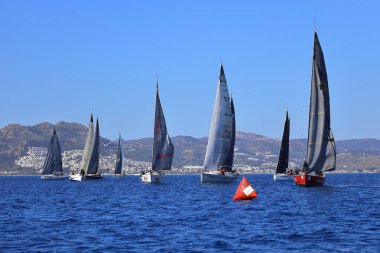 Bodrum, Hindi. 24 Şubat 2024: Ege Denizi 'nin mavi sularında, ünlü tatil beldesi Bodrum' un kıyılarında yelkenliler rüzgarlı havada yelken açıyor.