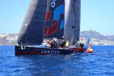 Bodrum, Hindi. 24 Şubat 2024: Ege Denizi 'nin mavi sularında, ünlü tatil beldesi Bodrum' un kıyılarında yelkenliler rüzgarlı havada yelken açıyor.