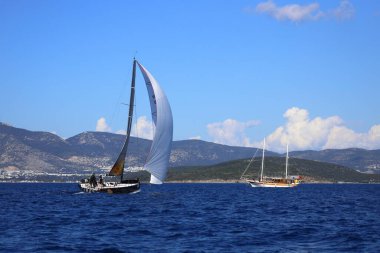 Bodrum, Hindi. 24 Şubat 2024: Ege Denizi 'nin mavi sularında, ünlü tatil beldesi Bodrum' un kıyılarında yelkenliler rüzgarlı havada yelken açıyor.
