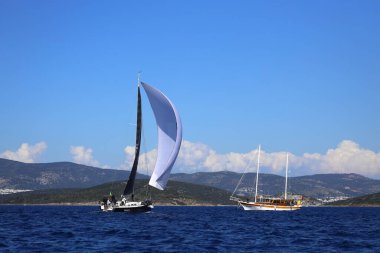 Bodrum, Hindi. 24 Şubat 2024: Ege Denizi 'nin mavi sularında, ünlü tatil beldesi Bodrum' un kıyılarında yelkenliler rüzgarlı havada yelken açıyor.
