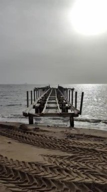 Eski terk edilmiş ahşap balıkçı iskelesi kırsal bölgedeki denizde. Sosyal medya için dikey video.