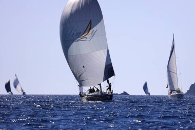 Bodrum, Hindi. 24 Şubat 2024: Ege Denizi 'nin mavi sularında, ünlü tatil beldesi Bodrum' un kıyılarında yelkenliler rüzgarlı havada yelken açıyor.