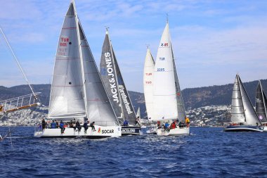 Bodrum, Hindi. 25 Şubat 2024: Ege Denizi 'nin mavi sularında, ünlü tatil beldesi Bodrum' un kıyılarında, rüzgarlı havada yelkenliler yelken açıyor.