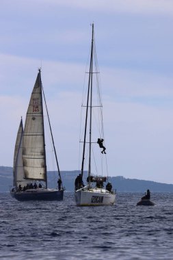 Bodrum, Hindi. 25 Şubat 2024: Yatın direğini asan ve tamir eden genç adam