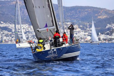 Bodrum, Hindi. 25 Şubat 2024: Ege Denizi 'nin mavi sularında, ünlü tatil beldesi Bodrum' un kıyılarında, rüzgarlı havada yelkenliler yelken açıyor.