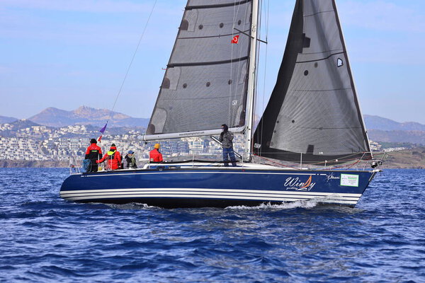 Бодрум, Турция. 25 февраля 2024: Парусники плывут в ветреную погоду в голубых водах Эгейского моря, на берегу знаменитого курорта Бодрум.