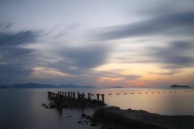 Sahilde gün batımı. Deniz kenti Turgutreis ve muhteşem gün batımları. Seçici Odaklanma. Uzun pozlu çekim. Huzur sahnesi.