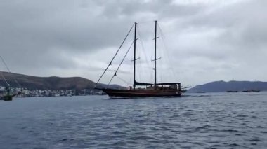Bodrum, Hindi. 26 Mayıs 2024: Yelkenliler Ege Denizi 'nin mavi sularında, ünlü tatil beldesi Bodrum' un kıyılarında rüzgarlı havada yelken açıyorlar..