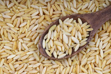 Çiğ taze ve sağlıklı organik arpa eriştesi ahşap kaşıkta.