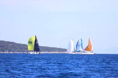 Bodrum, Hindi. 25 Şubat 2024: Ege Denizi 'nin mavi sularında, ünlü tatil beldesi Bodrum' un kıyılarında, rüzgarlı havada yelkenliler yelken açıyor.