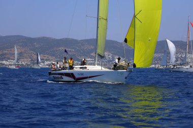 Bodrum, Hindi. 28 Nisan 2024: Yelkenliler Ege Denizi 'nin mavi sularında, ünlü tatil beldesi Bodrum' un kıyılarında rüzgarlı havada yelken açıyorlar..