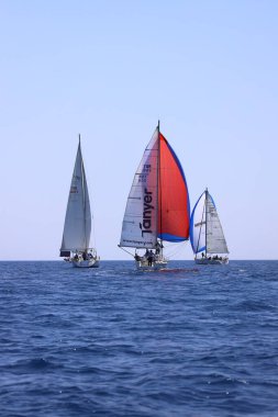 Bodrum, Hindi. 28 Nisan 2024: Yelkenliler Ege Denizi 'nin mavi sularında, ünlü tatil beldesi Bodrum' un kıyılarında rüzgarlı havada yelken açıyorlar..