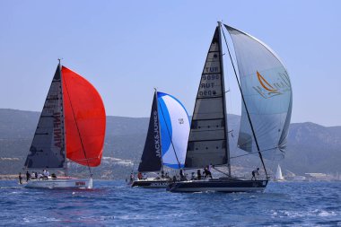 Bodrum, Hindi. 28 Nisan 2024: Yelkenliler Ege Denizi 'nin mavi sularında, ünlü tatil beldesi Bodrum' un kıyılarında rüzgarlı havada yelken açıyorlar..