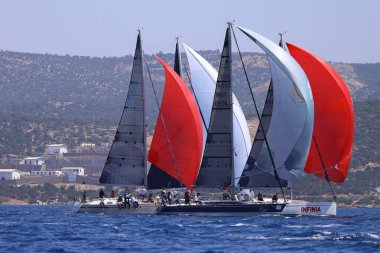 Bodrum, Hindi. 28 Nisan 2024: Yelkenliler Ege Denizi 'nin mavi sularında, ünlü tatil beldesi Bodrum' un kıyılarında rüzgarlı havada yelken açıyorlar..