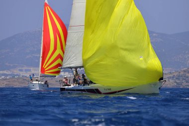 Bodrum, Hindi. 28 Nisan 2024: Yelkenliler Ege Denizi 'nin mavi sularında, ünlü tatil beldesi Bodrum' un kıyılarında rüzgarlı havada yelken açıyorlar..