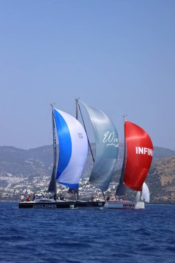 Bodrum, Hindi. 28 Nisan 2024: Yelkenliler Ege Denizi 'nin mavi sularında, ünlü tatil beldesi Bodrum' un kıyılarında rüzgarlı havada yelken açıyorlar..