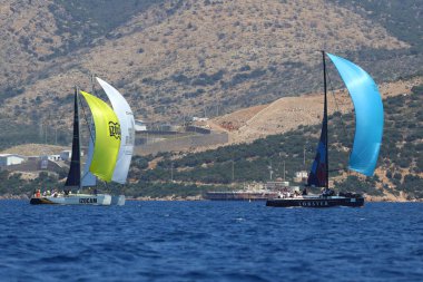 Bodrum, Hindi. 28 Nisan 2024: Yelkenliler Ege Denizi 'nin mavi sularında, ünlü tatil beldesi Bodrum' un kıyılarında rüzgarlı havada yelken açıyorlar..