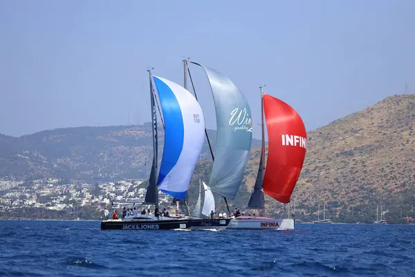 Bodrum, Hindi. 28 Nisan 2024: Yelkenliler Ege Denizi 'nin mavi sularında, ünlü tatil beldesi Bodrum' un kıyılarında rüzgarlı havada yelken açıyorlar..