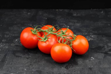 Siyah arka planda taze kiraz domatesleri. Siyah arka planda bir demet taze vişneli domates.
