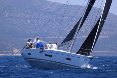 Bodrum, Hindi. 28 Nisan 2024: Yelkenliler Ege Denizi 'nin mavi sularında, ünlü tatil beldesi Bodrum' un kıyılarında rüzgarlı havada yelken açıyorlar..