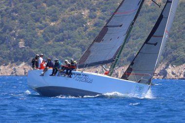 Bodrum, Hindi. 28 Nisan 2024: Yelkenliler Ege Denizi 'nin mavi sularında, ünlü tatil beldesi Bodrum' un kıyılarında rüzgarlı havada yelken açıyorlar..