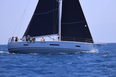 Bodrum, Hindi. 28 Nisan 2024: Yelkenliler Ege Denizi 'nin mavi sularında, ünlü tatil beldesi Bodrum' un kıyılarında rüzgarlı havada yelken açıyorlar..