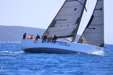 Bodrum, Hindi. 28 Nisan 2024: Yelkenliler Ege Denizi 'nin mavi sularında, ünlü tatil beldesi Bodrum' un kıyılarında rüzgarlı havada yelken açıyorlar..