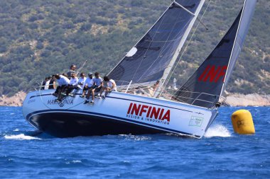 Bodrum, Hindi. 28 Nisan 2024: Yelkenliler Ege Denizi 'nin mavi sularında, ünlü tatil beldesi Bodrum' un kıyılarında rüzgarlı havada yelken açıyorlar..