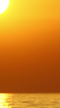 Güneş, denize batıyor. Görüntü akışını hızlandırmak mümkün. Sosyal medya için dikey video.