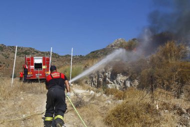 Bodrum, Hindi. 01 Ağustos 2020: Çimen tarlalarında, ormanlarda ve gökyüzüne siyah beyaz dumanlar saçan kırmızı ateş alevi. Yakından büyük bir yangın var. Hava konseptinde kirlilik.