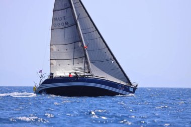 Bodrum, Hindi. 28 Nisan 2024: Yelkenliler Ege Denizi 'nin mavi sularında, ünlü tatil beldesi Bodrum' un kıyılarında rüzgarlı havada yelken açıyorlar..
