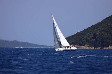 Bodrum, Hindi. 28 Nisan 2024: Yelkenliler Ege Denizi 'nin mavi sularında, ünlü tatil beldesi Bodrum' un kıyılarında rüzgarlı havada yelken açıyorlar..