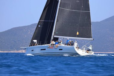 Bodrum, Hindi. 28 Nisan 2024: Yelkenliler Ege Denizi 'nin mavi sularında, ünlü tatil beldesi Bodrum' un kıyılarında rüzgarlı havada yelken açıyorlar..