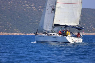 Bodrum, Hindi. 28 Nisan 2024: Yelkenliler Ege Denizi 'nin mavi sularında, ünlü tatil beldesi Bodrum' un kıyılarında rüzgarlı havada yelken açıyorlar..