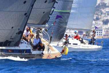 Bodrum, Hindi. 27 Nisan 2024: Ege Denizi 'nin mavi sularında, ünlü tatil beldesi Bodrum' un kıyılarında yelkenliler rüzgarlı havada yelken açıyor.