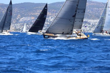 Bodrum, Hindi. 27 Nisan 2024: Ege Denizi 'nin mavi sularında, ünlü tatil beldesi Bodrum' un kıyılarında yelkenliler rüzgarlı havada yelken açıyor.