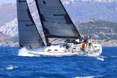 Bodrum, Hindi. 27 Nisan 2024: Ege Denizi 'nin mavi sularında, ünlü tatil beldesi Bodrum' un kıyılarında yelkenliler rüzgarlı havada yelken açıyor.