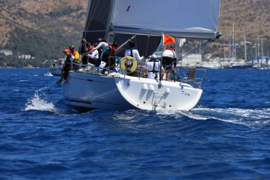 Bodrum, Hindi. 27 Nisan 2024: Ege Denizi 'nin mavi sularında, ünlü tatil beldesi Bodrum' un kıyılarında yelkenliler rüzgarlı havada yelken açıyor.