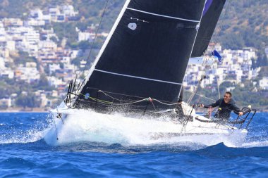 Bodrum, Hindi. 27 Nisan 2024: Ege Denizi 'nin mavi sularında, ünlü tatil beldesi Bodrum' un kıyılarında yelkenliler rüzgarlı havada yelken açıyor.