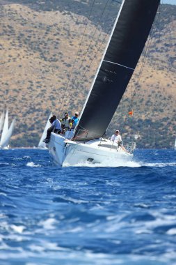 Bodrum, Hindi. 27 Nisan 2024: Ege Denizi 'nin mavi sularında, ünlü tatil beldesi Bodrum' un kıyılarında yelkenliler rüzgarlı havada yelken açıyor.