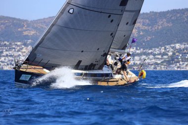 Bodrum, Hindi. 27 Nisan 2024: Ege Denizi 'nin mavi sularında, ünlü tatil beldesi Bodrum' un kıyılarında yelkenliler rüzgarlı havada yelken açıyor.