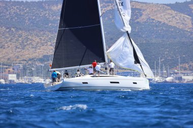 Bodrum, Hindi. 27 Nisan 2024: Ege Denizi 'nin mavi sularında, ünlü tatil beldesi Bodrum' un kıyılarında yelkenliler rüzgarlı havada yelken açıyor.