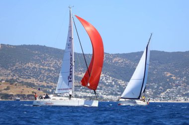 Bodrum, Hindi. 27 Nisan 2024: Ege Denizi 'nin mavi sularında, ünlü tatil beldesi Bodrum' un kıyılarında yelkenliler rüzgarlı havada yelken açıyor.