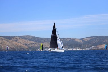 Bodrum, Hindi. 27 Nisan 2024: Ege Denizi 'nin mavi sularında, ünlü tatil beldesi Bodrum' un kıyılarında yelkenliler rüzgarlı havada yelken açıyor.