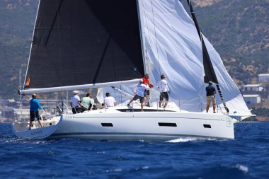 Bodrum, Hindi. 27 Nisan 2024: Ege Denizi 'nin mavi sularında, ünlü tatil beldesi Bodrum' un kıyılarında yelkenliler rüzgarlı havada yelken açıyor.