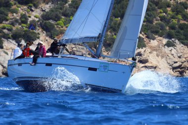 Bodrum, Hindi. 27 Nisan 2024: Ege Denizi 'nin mavi sularında, ünlü tatil beldesi Bodrum' un kıyılarında yelkenliler rüzgarlı havada yelken açıyor.