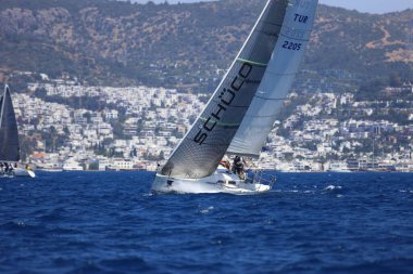 Bodrum, Hindi. 27 Nisan 2024: Ege Denizi 'nin mavi sularında, ünlü tatil beldesi Bodrum' un kıyılarında yelkenliler rüzgarlı havada yelken açıyor.