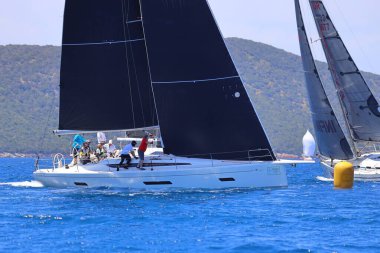 Bodrum, Hindi. 27 Nisan 2024: Ege Denizi 'nin mavi sularında, ünlü tatil beldesi Bodrum' un kıyılarında yelkenliler rüzgarlı havada yelken açıyor.